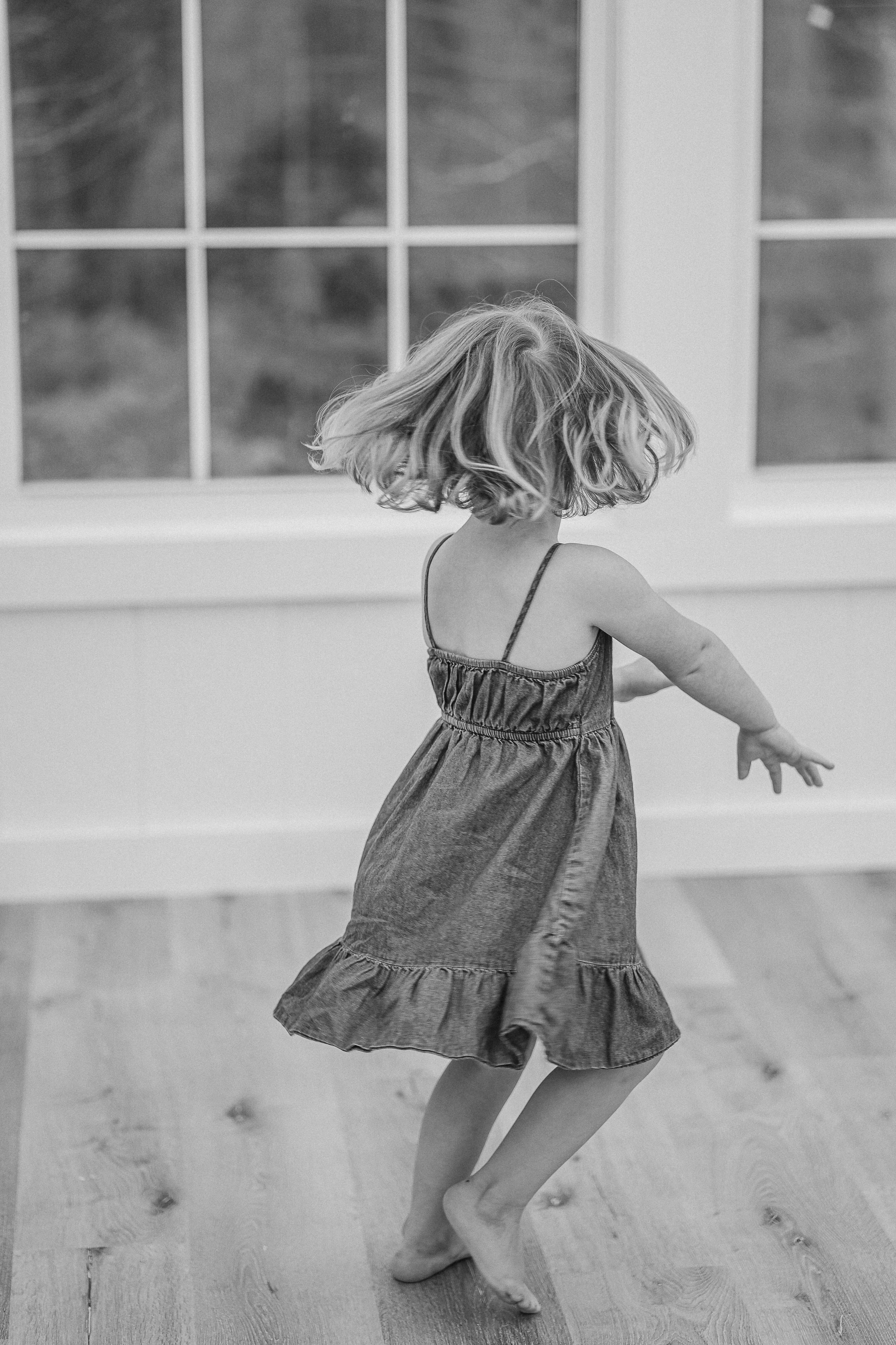 Little girl twirling in her dress in the bright studio