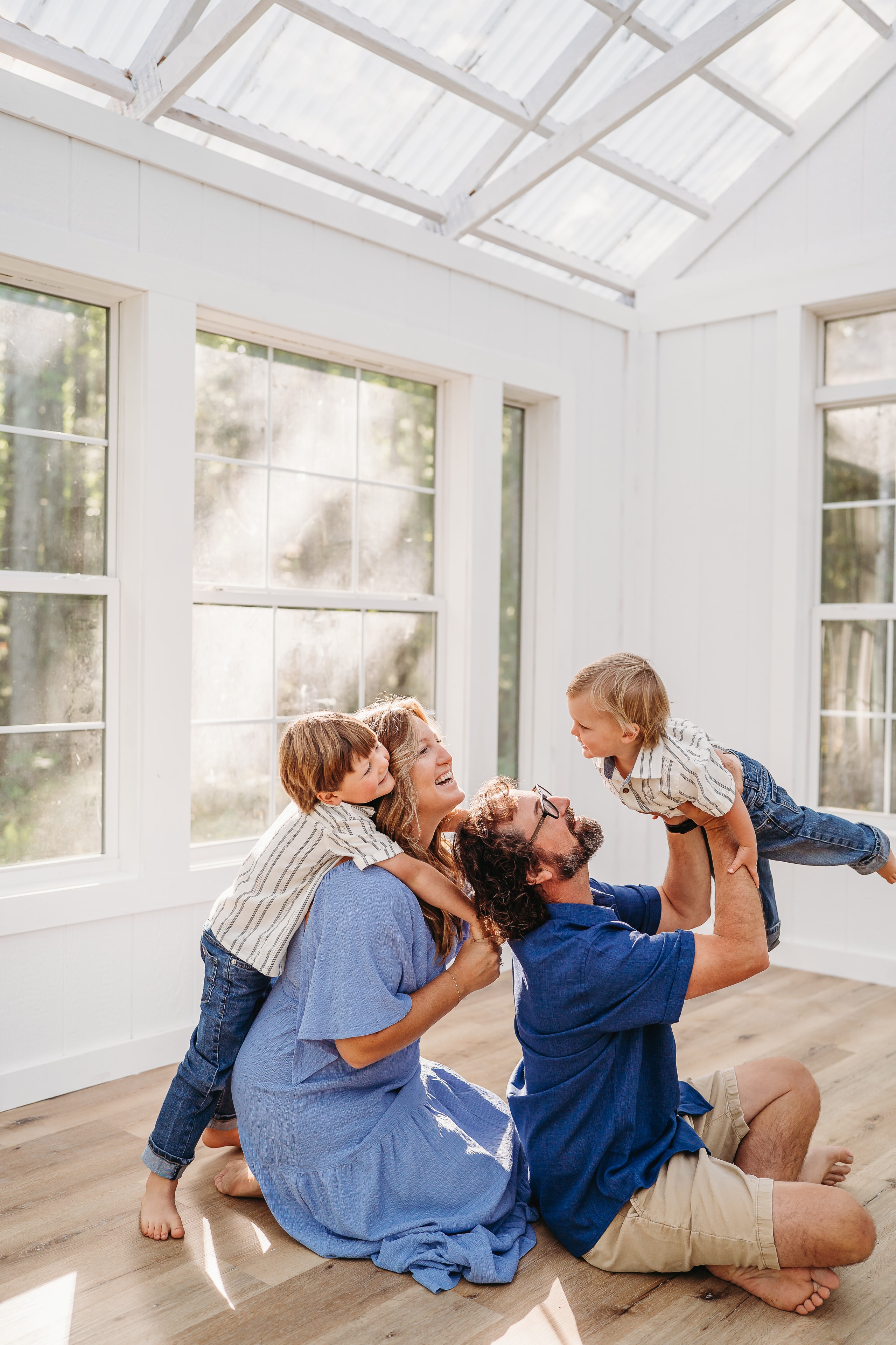 Parents playing with their two young sons inside the sunlit studio