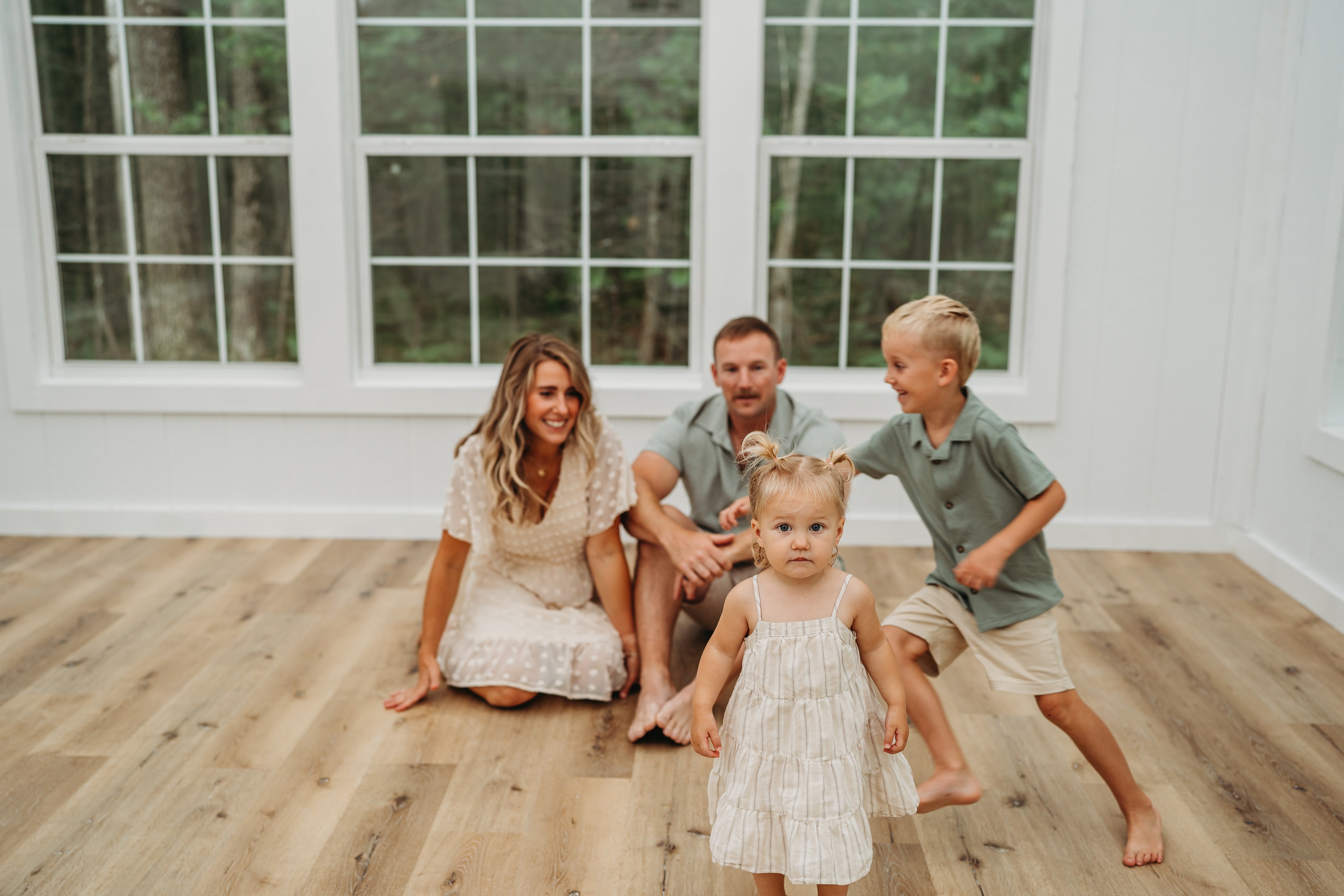 Family playing together on the studio floor by the large windows